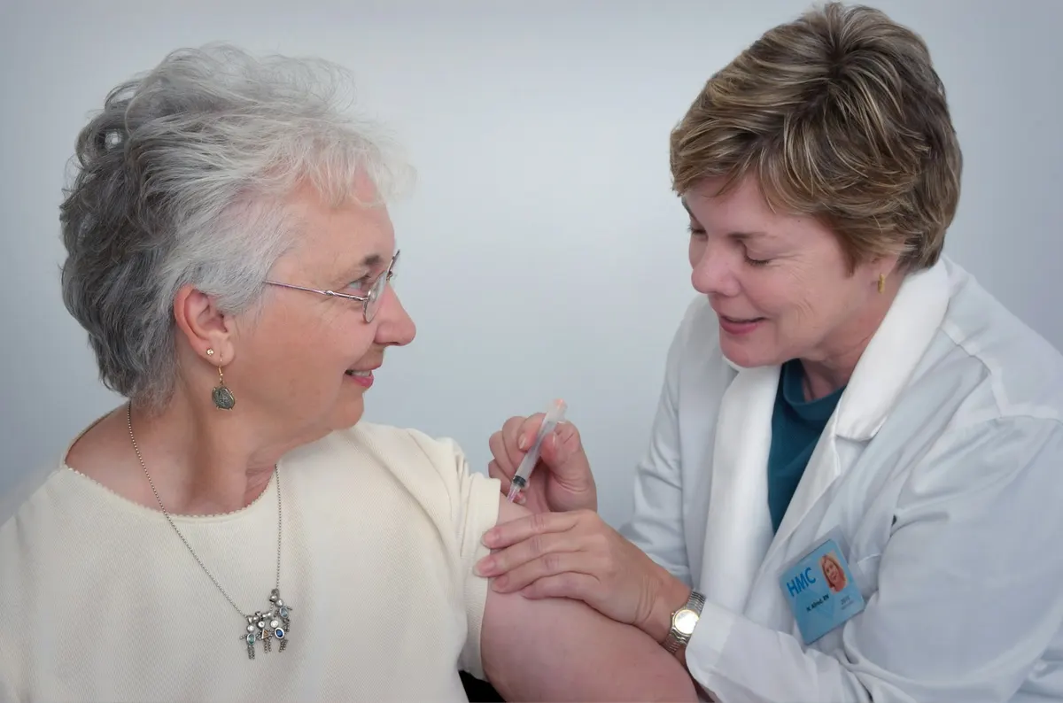 A physician talking with an older patient in an exam room